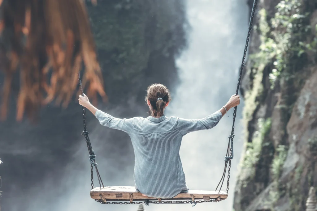 woman on a swing by the waterfall